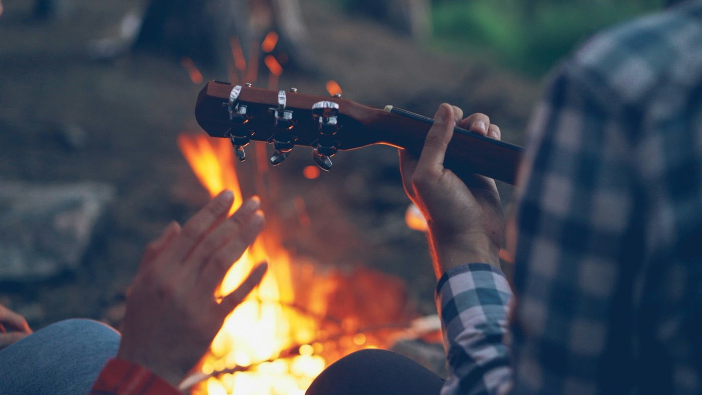 A guitar played beside the fire