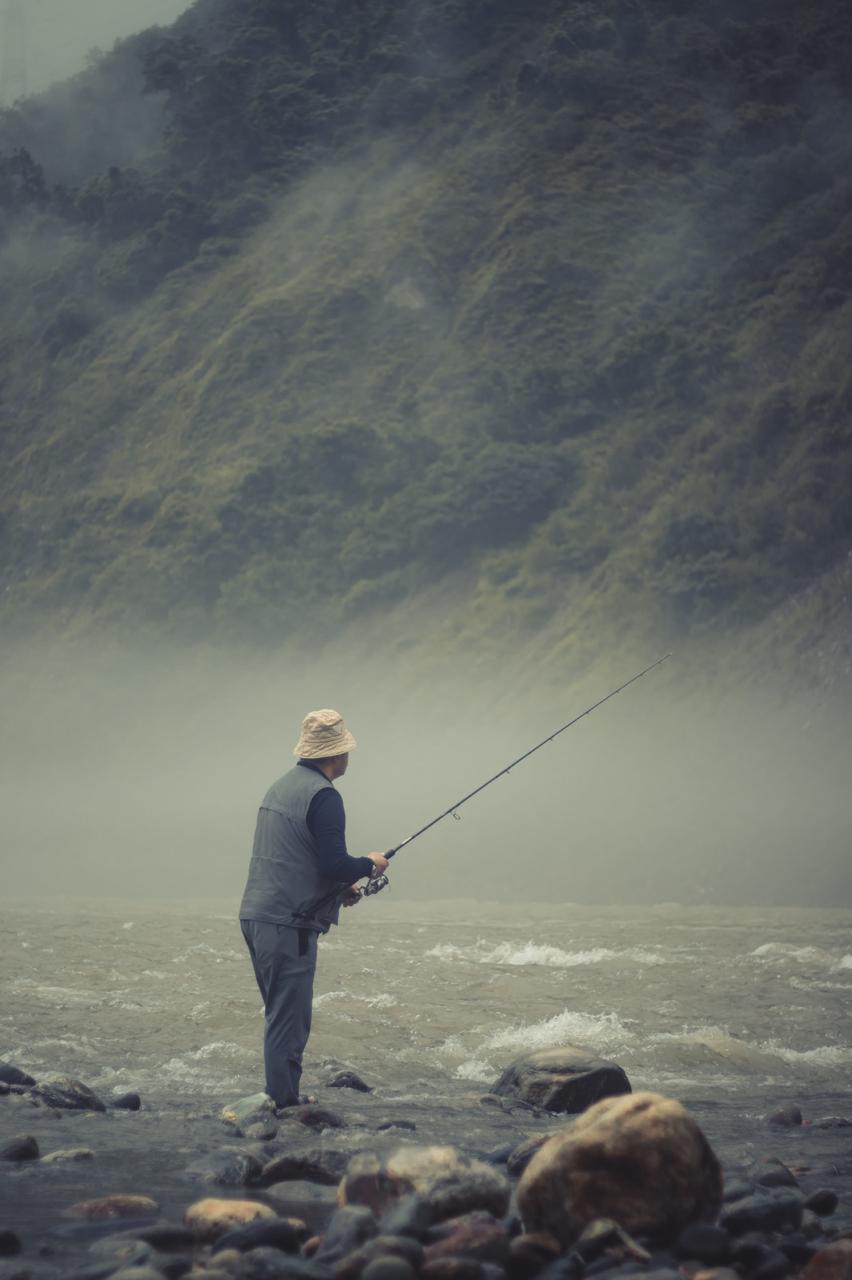 An angler casting into the misty Rangeet